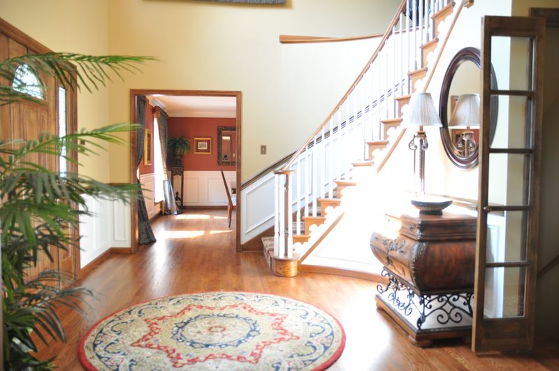 Foyer with a curved staircase and hardwood floors