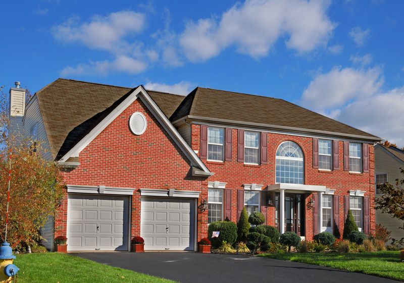Red brick colonial with a two-car front garage